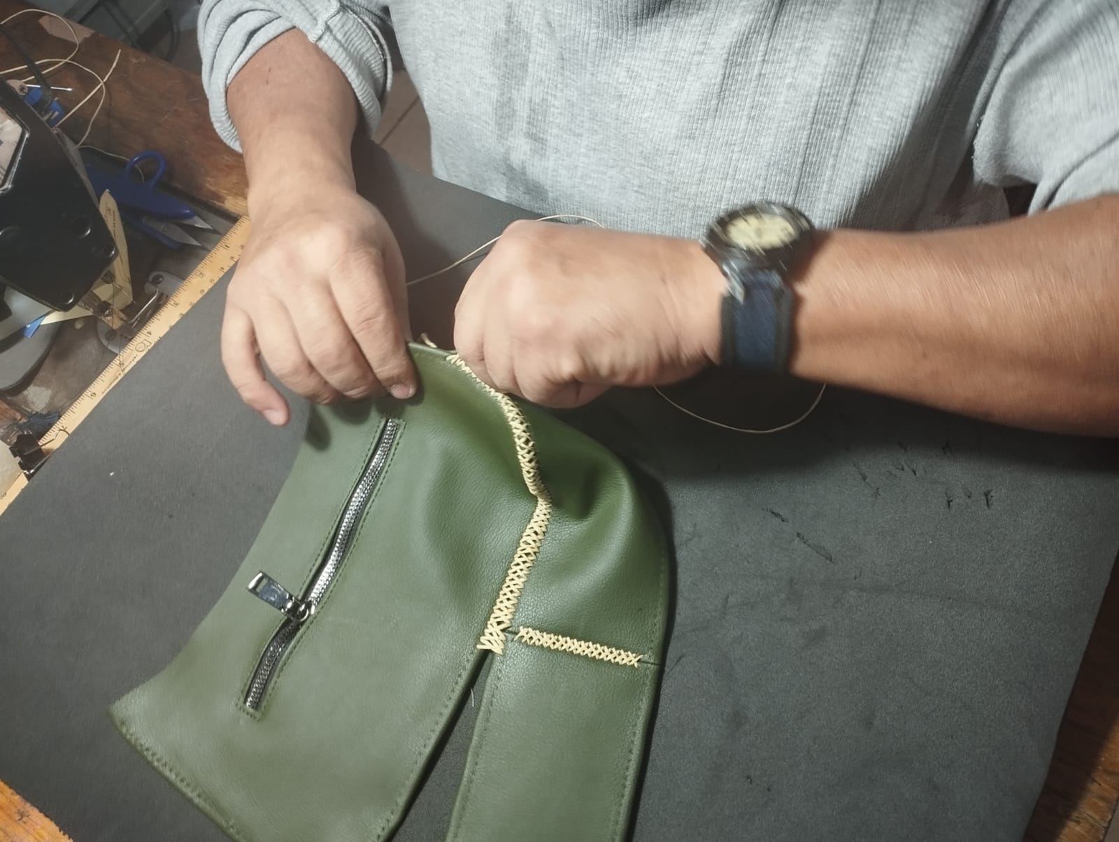 [Manos de artesana bordando el logo]